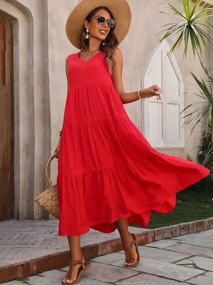Woman in red tiered maxi dress, straw hat, and sandals for summer fashion