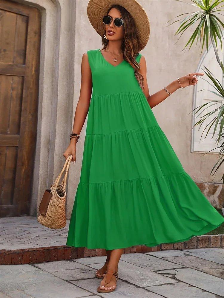Woman in green tiered maxi dress, straw hat, and woven bag for summer fashion