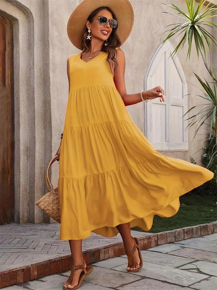 Woman in yellow tiered midi dress, straw hat, and sandals for summer fashion