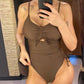 Woman in brown ruched one-piece swimsuit with side tie, taking mirror selfie