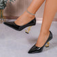 Black patent leather pumps with gold treble clef heels, worn with crystal anklet, stylish women's fashion footwear