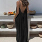 Woman in black backless maxi dress, summer fashion, boho style, outdoor setting with ceramic bowls