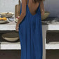 Woman in blue backless maxi dress at outdoor table with fruit bowls, summer fashion style