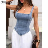 Women's denim corset top with square neckline, paired with white pants for stylish fashion look