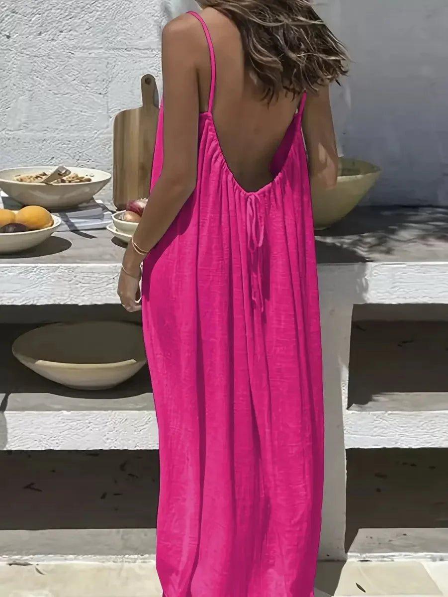 Woman in vibrant pink backless maxi dress, summer fashion, outdoor dining setting
