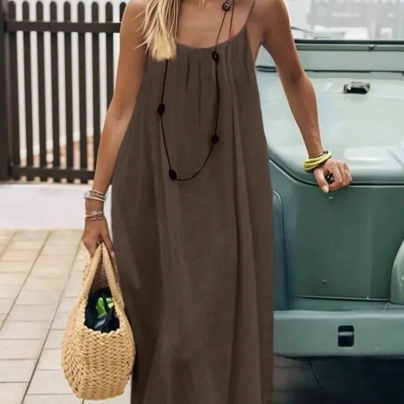 Woman in brown sleeveless maxi dress with straw bag, summer fashion outfit