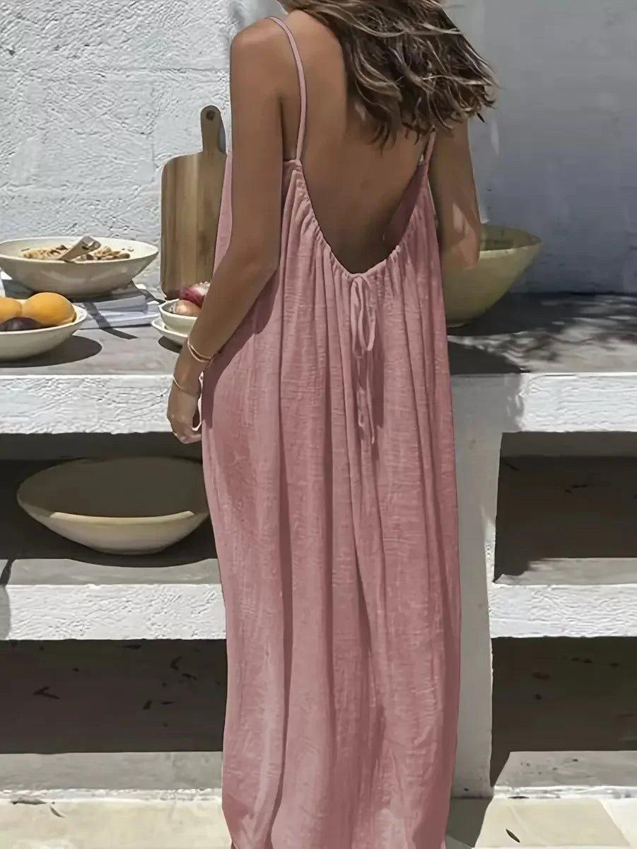 Woman in pink backless maxi dress, summer fashion, outdoor dining setting