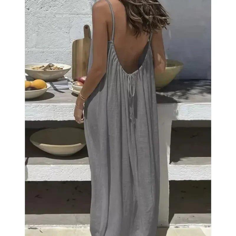 Woman in gray backless maxi dress, summer fashion, casual beach style, outdoor dining setting