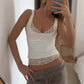 Woman in white lace-trim tank top and gray ribbed shorts, taking mirror selfie for fashion outfit inspiration