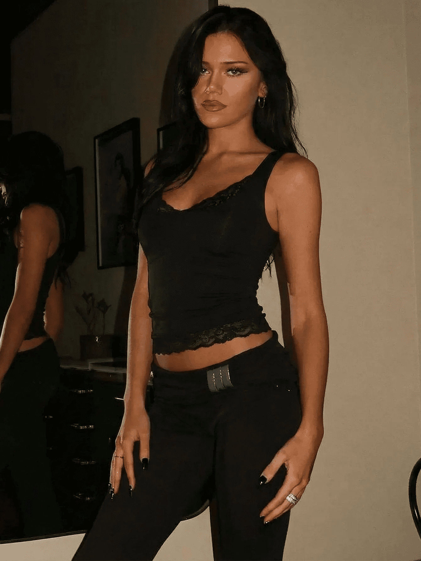 Woman in black lace crop top and high-waist pants, stylish fashion outfit