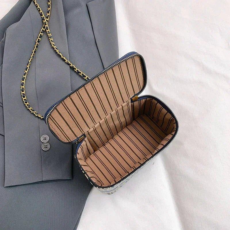 Stylish women's crossbody bag with gold chain strap and striped interior, perfect for fashion outfits