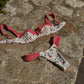 Floral print bikini with red gingham trim, laid on stone surface
