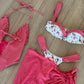 Red gingham and floral print women's swimwear set on wood floor