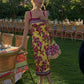 Woman in yellow floral midi dress at outdoor garden party, summer fashion