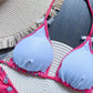 Pink floral bikini top with white lining, styled with straw hat on woven mat
