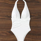 White halter neck one-piece swimsuit with ruched waist, perfect for beach fashion
