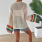 Women's open knit cardigan with rainbow striped sleeves, paired with denim shorts for casual summer fashion