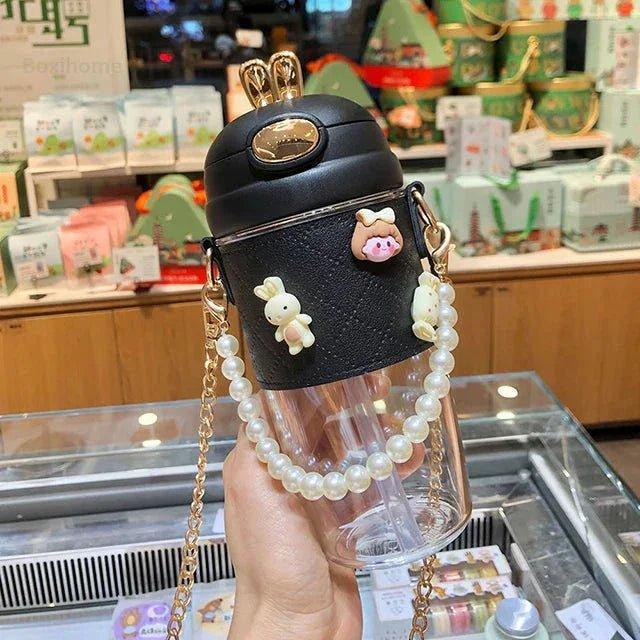 Cute black travel mug with pearl strap, bunny charms, and gold lid for women's fashion