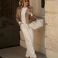 Woman in beige trench coat, white ribbed top, wide-leg pants, sunglasses, and cream tote bag