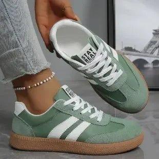 Mint green women's fashion sneakers with white stripes and gum sole, styled with jeans and anklet