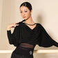 Woman in elegant black dance top with draped neckline and sheer waist panel, perfect for ballroom fashion.