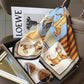 Elegant horse-print silk scarf with sunglasses and LOEWE magazine, perfect for women's fashion accessories.