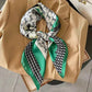 Stylish green and white patterned silk scarf tied on beige blazer, fashion accessory for women