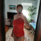 Woman in red one-shoulder swimsuit taking mirror selfie at home, fashion swimwear style