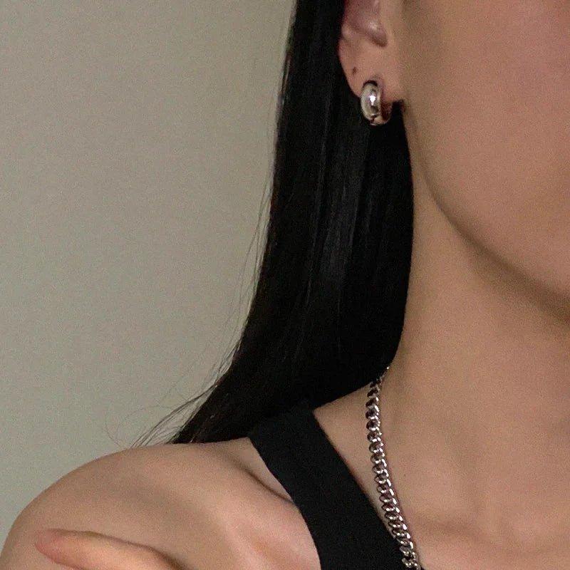 Silver hoop earring and chain necklace on woman with black hair, fashion jewelry