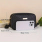 Black quilted crossbody bag with gold hardware, shown with phone for scale, perfect for women's fashion