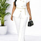 White women's fashion suit with gold floral buttons, chain belt, and black heels, styled for elegance.