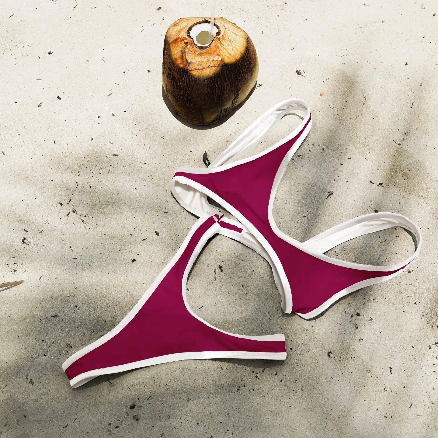 Purple and white bikini set on sandy beach with fresh coconut, perfect for summer fashion