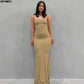Woman in elegant beige spaghetti strap maxi dress, perfect for evening events or fashion-forward looks.