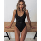 Woman in black ribbed one-piece swimsuit with belt, stylish beachwear fashion