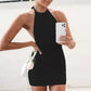 Woman in black halter neck mini dress taking mirror selfie with white phone and rose clutch