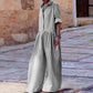 Woman wearing black and white gingham jumpsuit with wide legs, standing on stone street