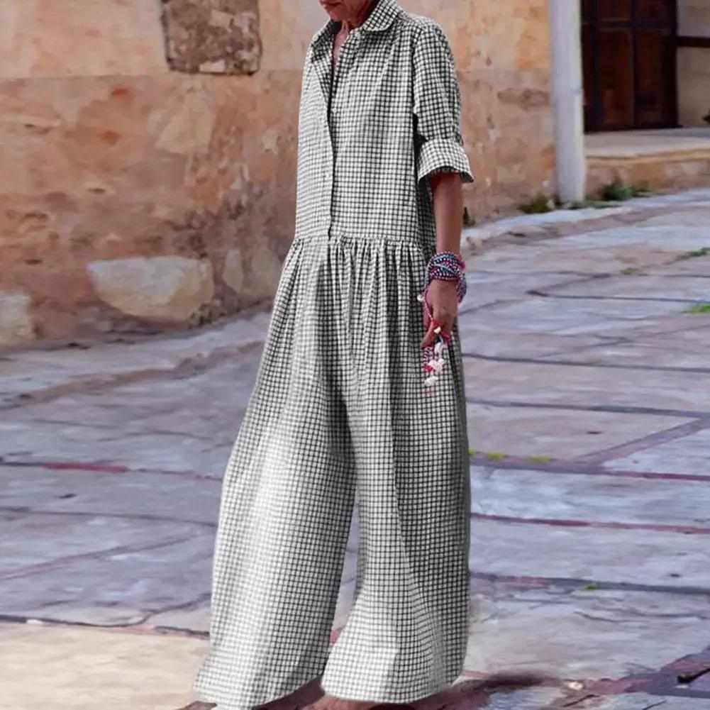 Woman wearing black and white gingham jumpsuit with wide legs, standing on stone street