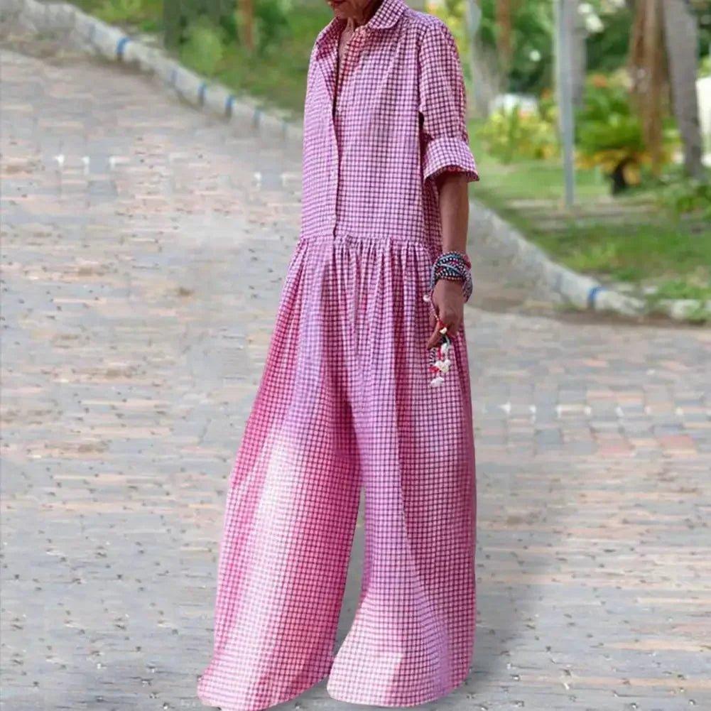 Woman in pink gingham jumpsuit with wide legs, walking outdoors on paved path