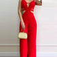 Red cutout jumpsuit for women, stylish wide-leg fashion with gold clutch accessory