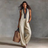 Woman in beige sleeveless jumpsuit with black embroidery, carrying woven tote bag, summer fashion style