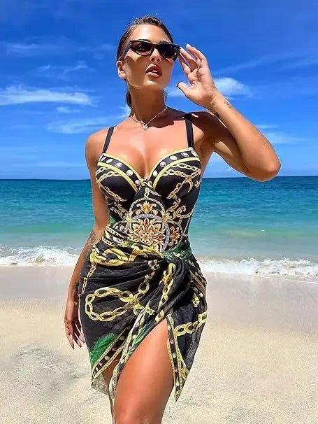 Woman in stylish black and gold chain print beach dress, sunglasses, ocean backdrop