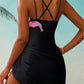 Black one-piece swimsuit with pink floral print and crisscross back, beach fashion for women