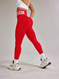 Red high-waisted leggings with 'BEGIN' print, white sports bra, and chunky sneakers for women's fitness fashion