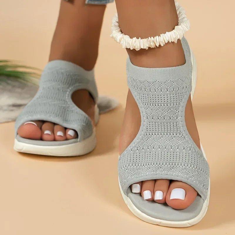 Light gray knit women's sandals with ruffled ankle strap, white soles, and open toe design