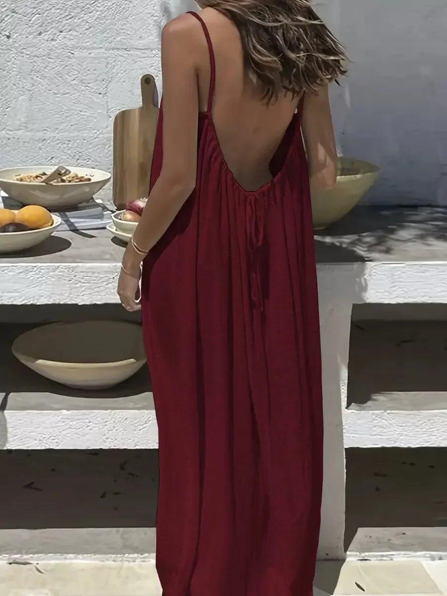 Woman in red backless maxi dress, summer fashion, beach style, boho chic, outdoor setting