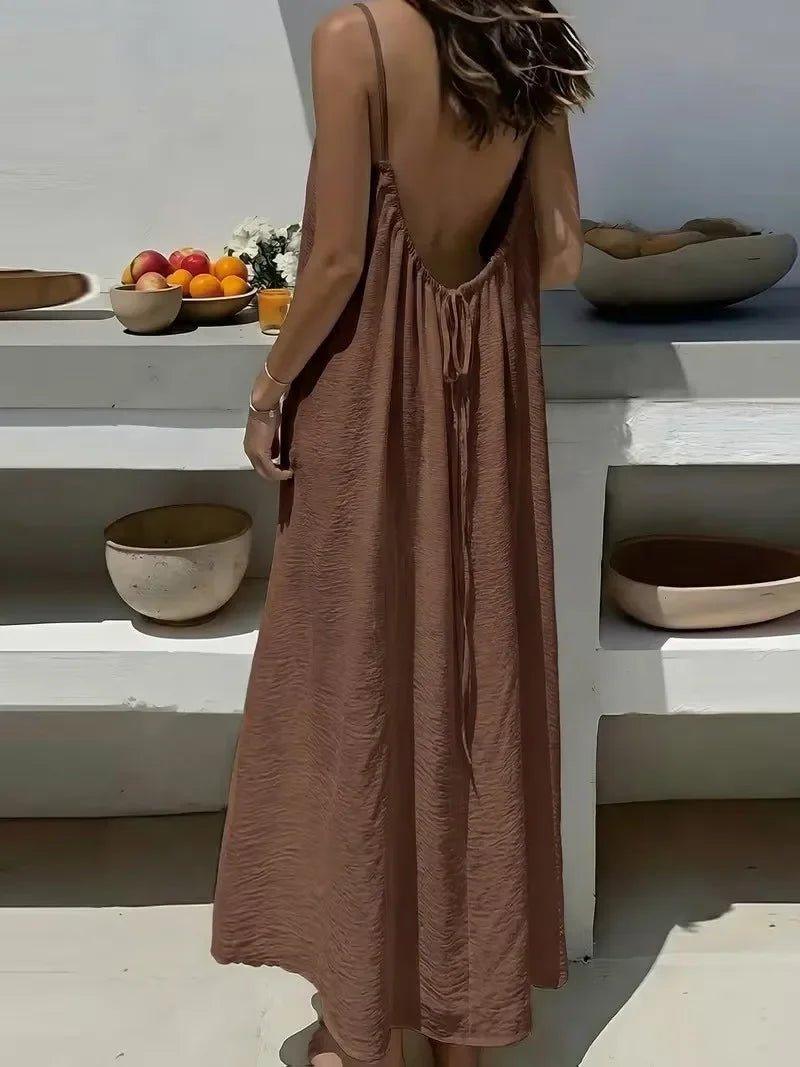 Woman in backless brown maxi dress, summer fashion, beach style, elegant flowy dress